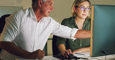 Buy stock photo Cropped shot of two businesspeople working together on a computer in their office