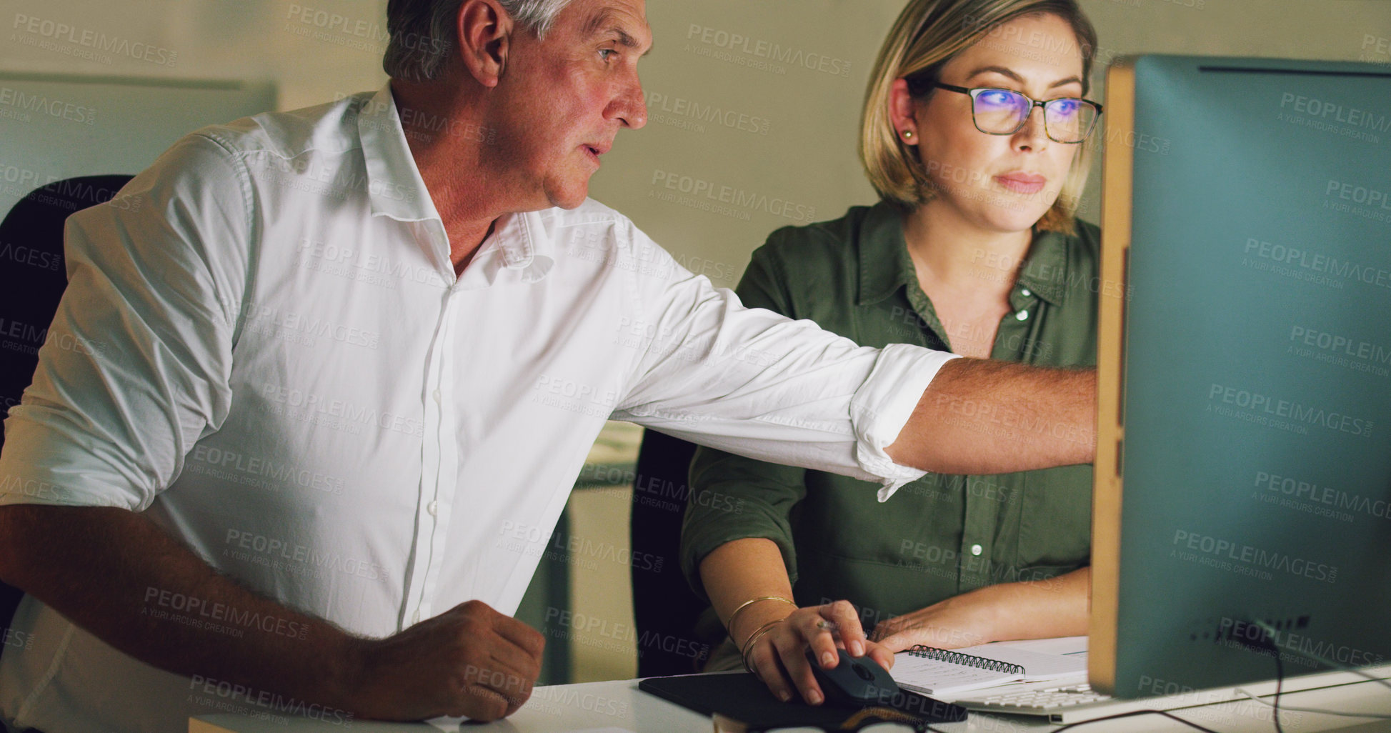 Buy stock photo Cropped shot of two businesspeople working together on a computer in their office