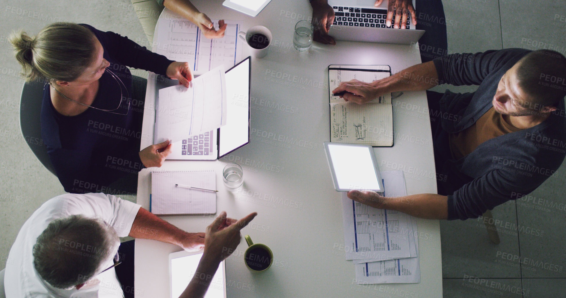 Buy stock photo High angle shot of a group of businesspeople working together around a table in their office