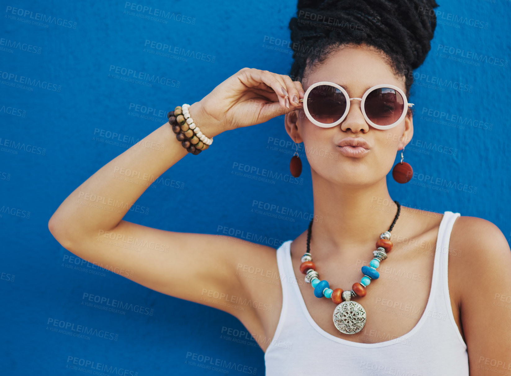 Buy stock photo Shot of an attractive young woman wearing funky sunglasses against a blue background