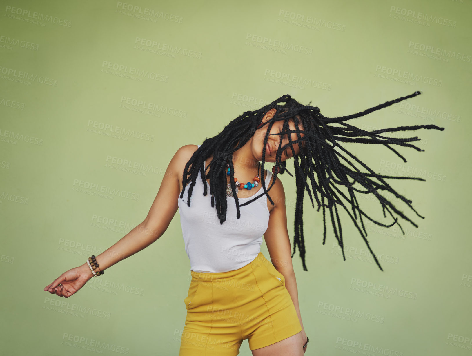 Buy stock photo Shot of an attractive young woman dancing against a green background