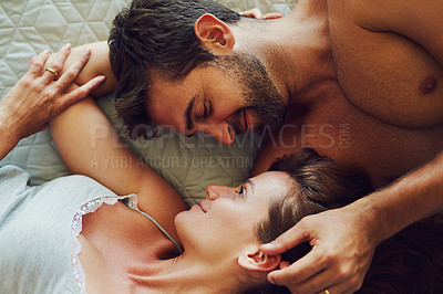 Buy stock photo High angle shot of an affectionate couple lying in bed together