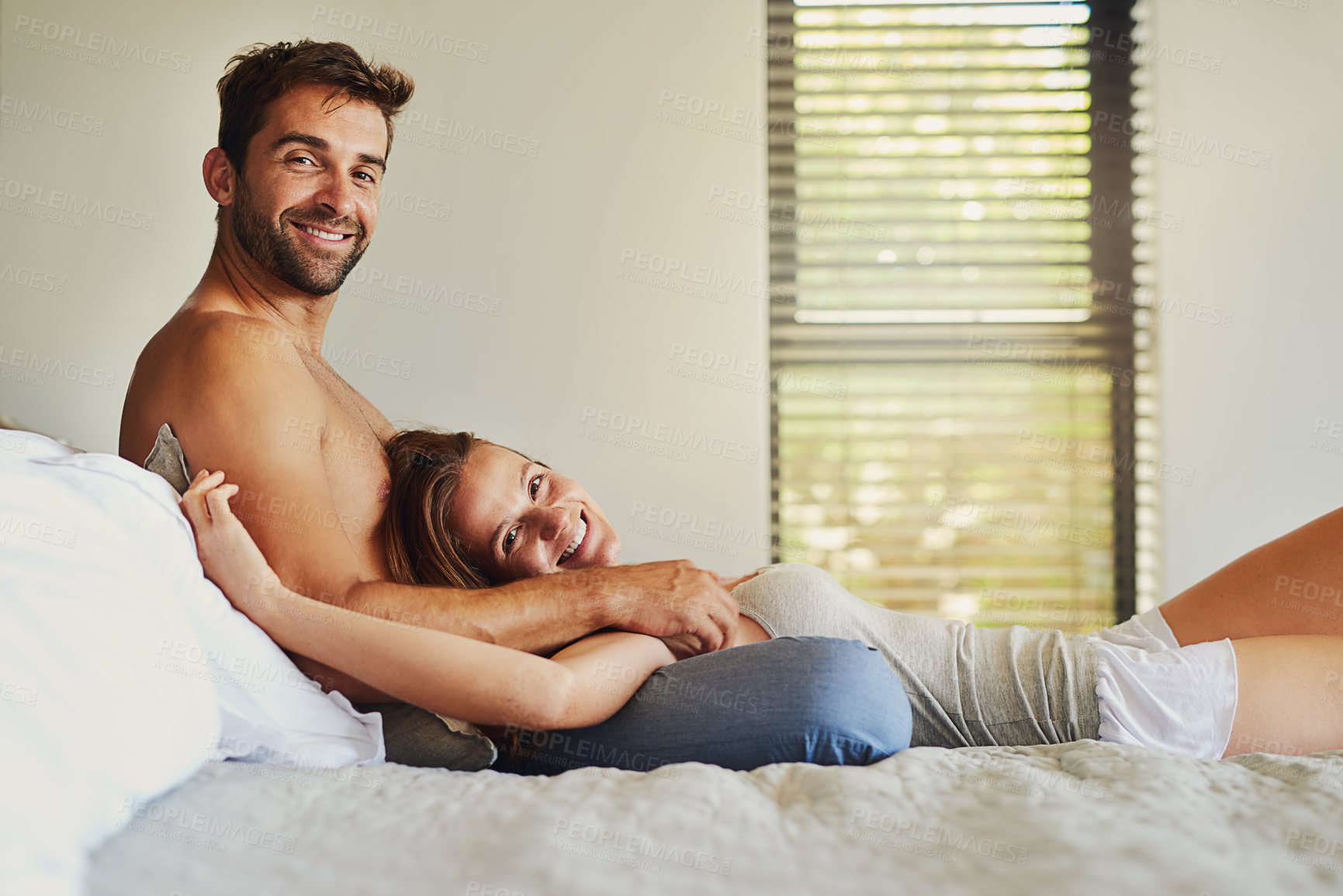 Buy stock photo Portrait, smile and couple relax on bed at house with love, playful game and bonding embrace of marriage romance. Happy, woman and man in bedroom with care, loyalty and relationship commitment