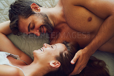 Buy stock photo High angle shot of an affectionate couple lying in bed together
