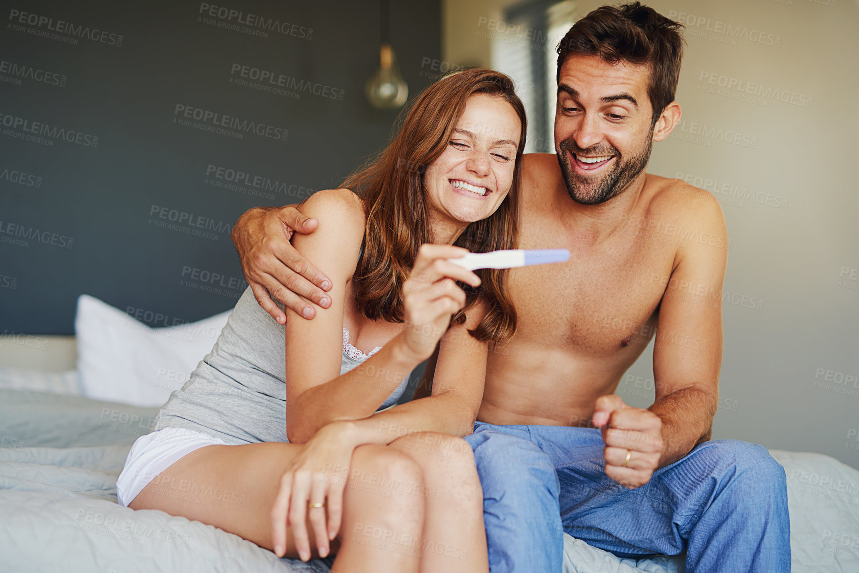 Buy stock photo Shot of a young couple looking at the results on a pregnancy test