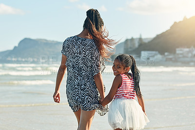Buy stock photo Portrait of a little girl enjoying a walk along the beach with her mother