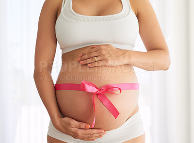 Buy stock photo Cropped shot of a woman with a pink ribbon tied around her pregnant belly