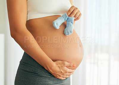 Buy stock photo Pregnancy, baby socks and mother in home holding belly bump for gender reveal, bonding or connection. Love, prenatal care and body of maternal woman with bootee by stomach for child in house.