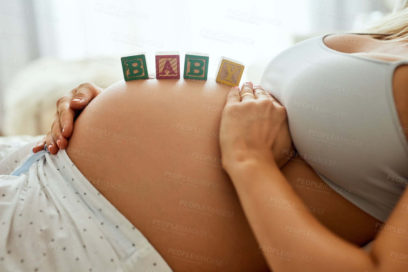 Buy stock photo Woman, pregnant and letter blocks on belly for baby announcement, wellness and support in home. Future mom, pregnancy and wood puzzle on stomach with excited for motherhood, love and maternity leave