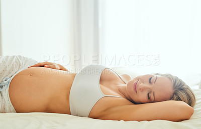 Buy stock photo Shot of a pregnant woman sleeping peacefully on her bed