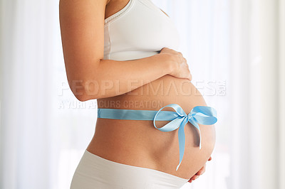 Buy stock photo Cropped shot of a woman with a blue ribbon tied around her pregnant belly