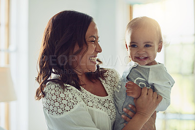 Buy stock photo Shot of a mother and her adorable son smiling together at home