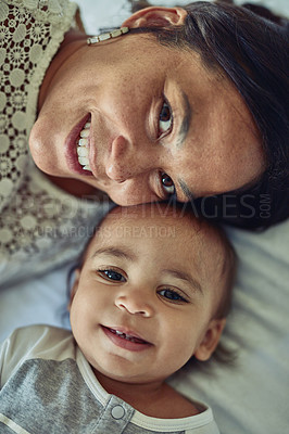 Buy stock photo Shot of a mother and her adorable son lying down together at home