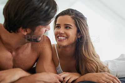Buy stock photo Shot of a happy young couple relaxing together in bed
