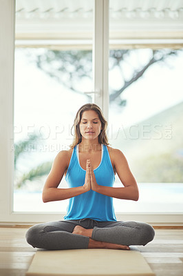 Buy stock photo Full length shot of a young woman practicing yoga at home