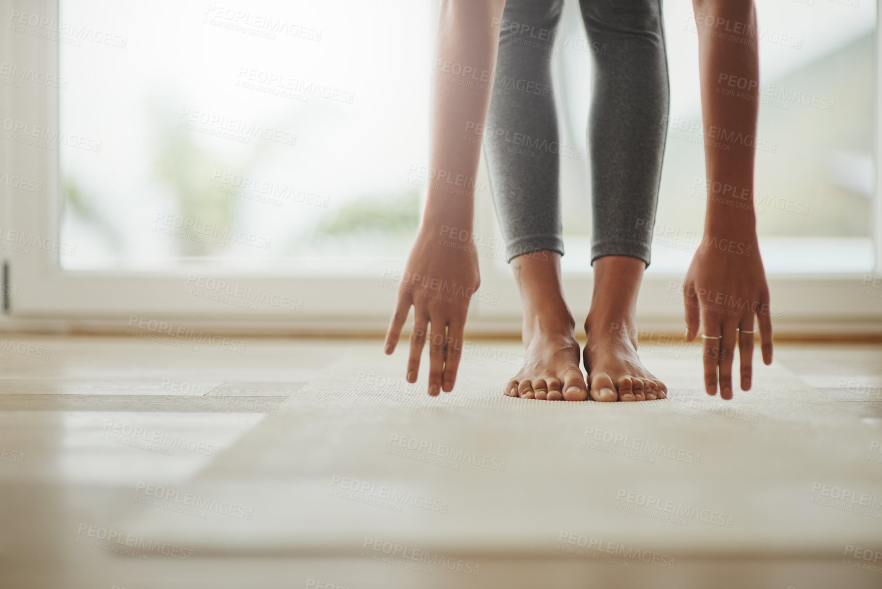 Buy stock photo Cropped shot of a young woman practicing yoga at home