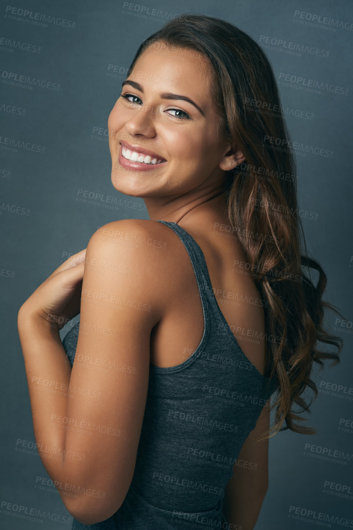 Buy stock photo Studio shot of a beautiful young woman against a blue background