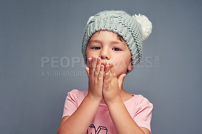 Buy stock photo Studio portrait of an adorable little boy blowing kisses against a gray background