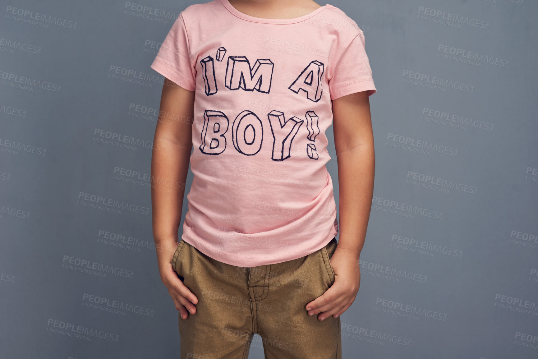 Buy stock photo Kid, affirmation and text on shirt for gender identity, style and youth fashion model by gray background. Confident, toddler or boy with pink clothes for choice, learning and proud print with color