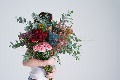 Buy stock photo Natural, gift and woman with flowers, spring and eco friendly against grey background. Female person, model and girl with a floral present, bouquet or hide face with sustainability, nature and plants