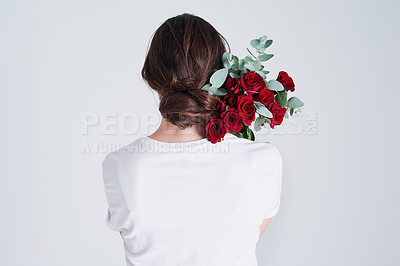 Buy stock photo Studio shot of an unrecognizable woman holding flowers against a grey background
