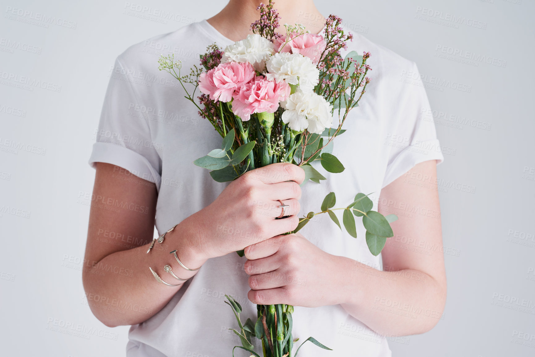 Buy stock photo Studio shot of an unrecognizable woman holding a bunch of flowers against a grey background