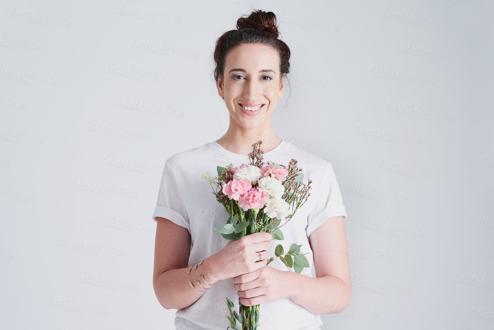 Buy stock photo Studio shot of a beautiful young woman holding a bouquet of flowers against a grey background