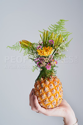 Buy stock photo Studio shot of an unrecognizable woman holding a pineapple against a grey background