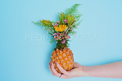 Buy stock photo Shot of an unrecognizable woman holding a pineapple stuffed with flowers