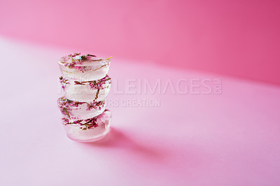 Buy stock photo Studio shot of flowers frozen into ice blocks against a pink background