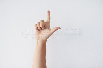 Buy stock photo Cropped shot of a unrecognizable person's hands against a grey background showing a letter 
