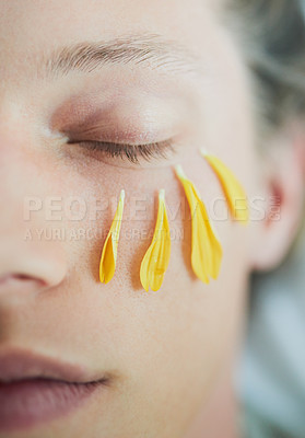 Buy stock photo Facial, skincare and woman with flower petals for organic beauty treatment or dermatology closeup. Eyes closed, cosmetics and natural floral plant leaves on half face for peace, calm and relax at spa