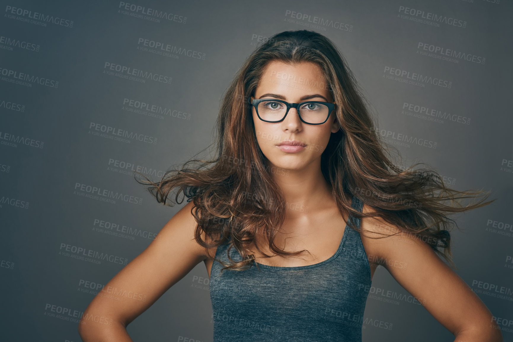 Buy stock photo Breeze, hair care and portrait of woman with confidence for beauty, makeup or wind. Hairstyle, face and model in glasses at hairdresser for salon treatment cosmetic isolated on gray studio background