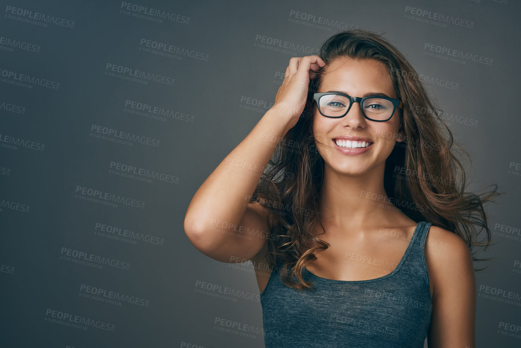 Buy stock photo Young woman, glasses and portrait with happiness and mockup from eyewear. Gray background, studio and mockup with female person and model with beauty and casual style with a smile and eye care