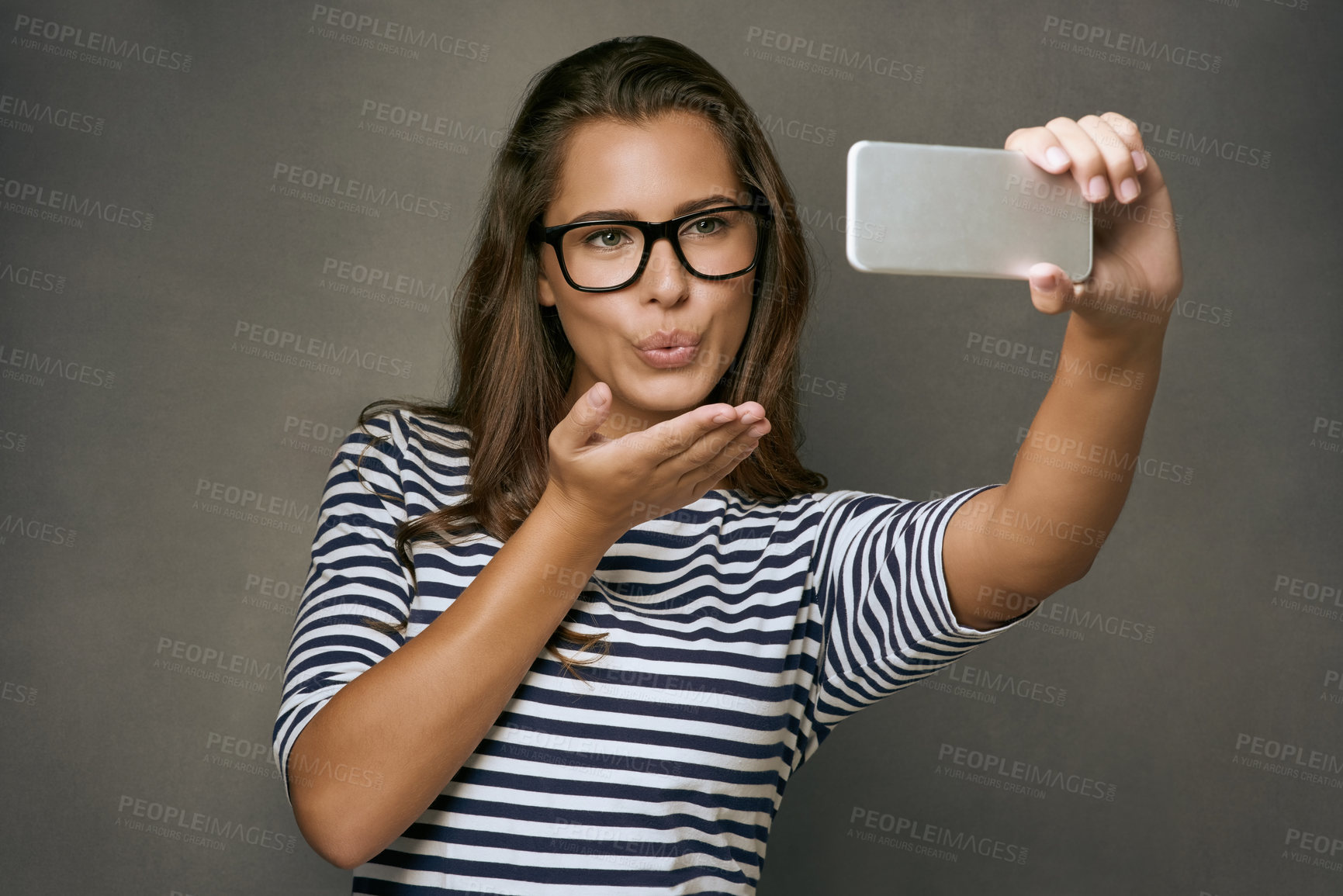 Buy stock photo Woman, kiss and selfie with glasses in studio for social media post, eyewear update and prescription for vision. Girl, photography and gray background with spectacles for eye care and optometry.