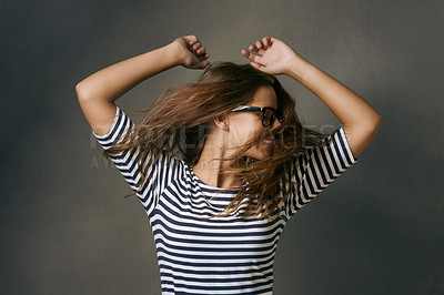 Buy stock photo Studio shot of a young woman dancing against a dark background