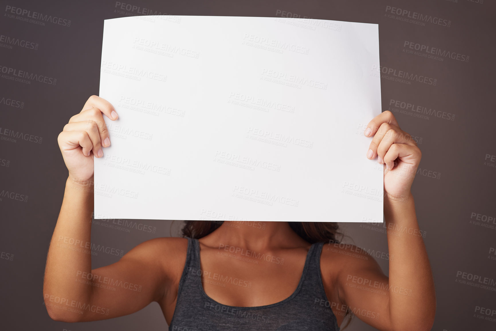 Buy stock photo Studio shot of an attractive young woman holding a blank placard against a gray background
