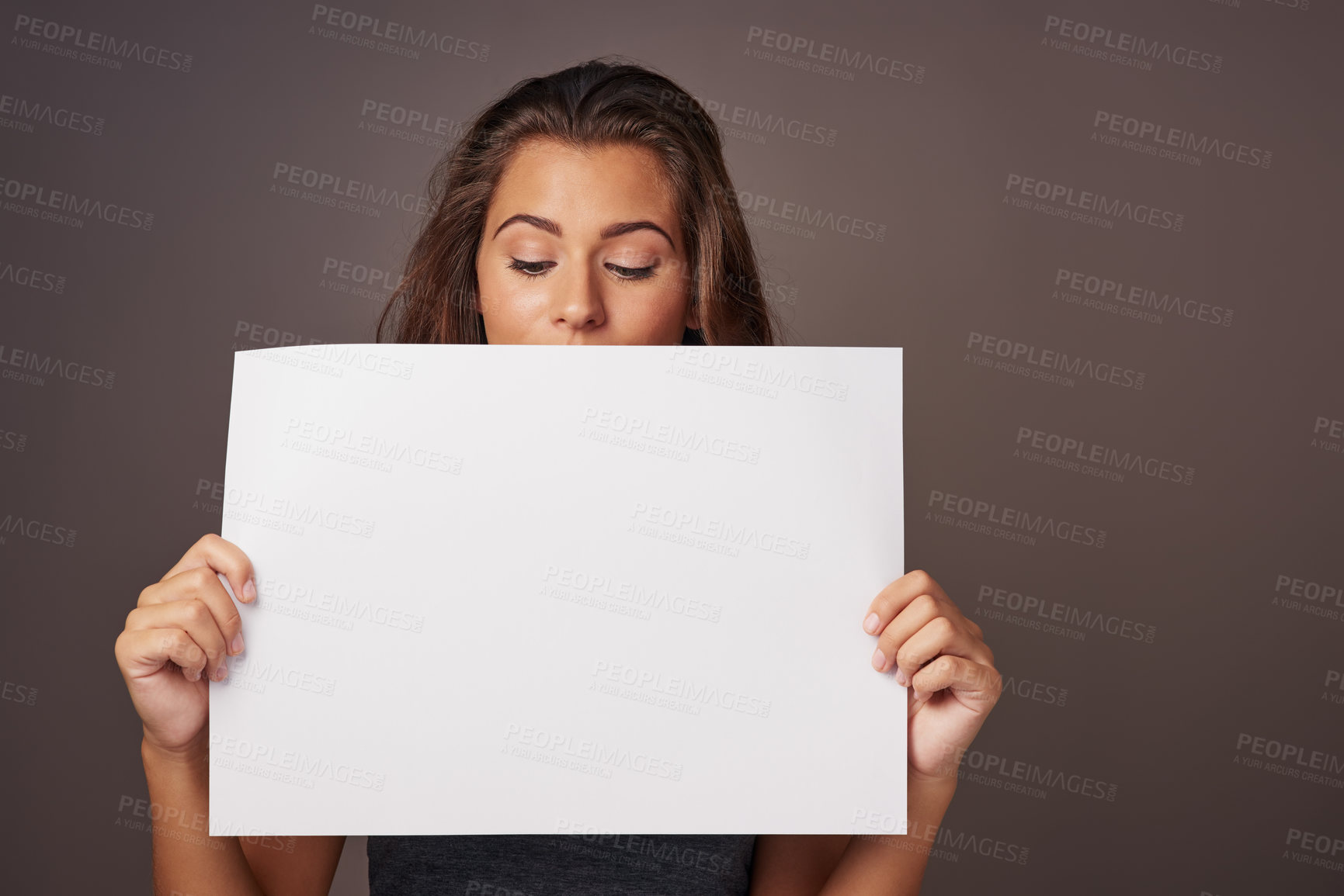 Buy stock photo Studio shot of an attractive young woman holding a blank placard against a gray background