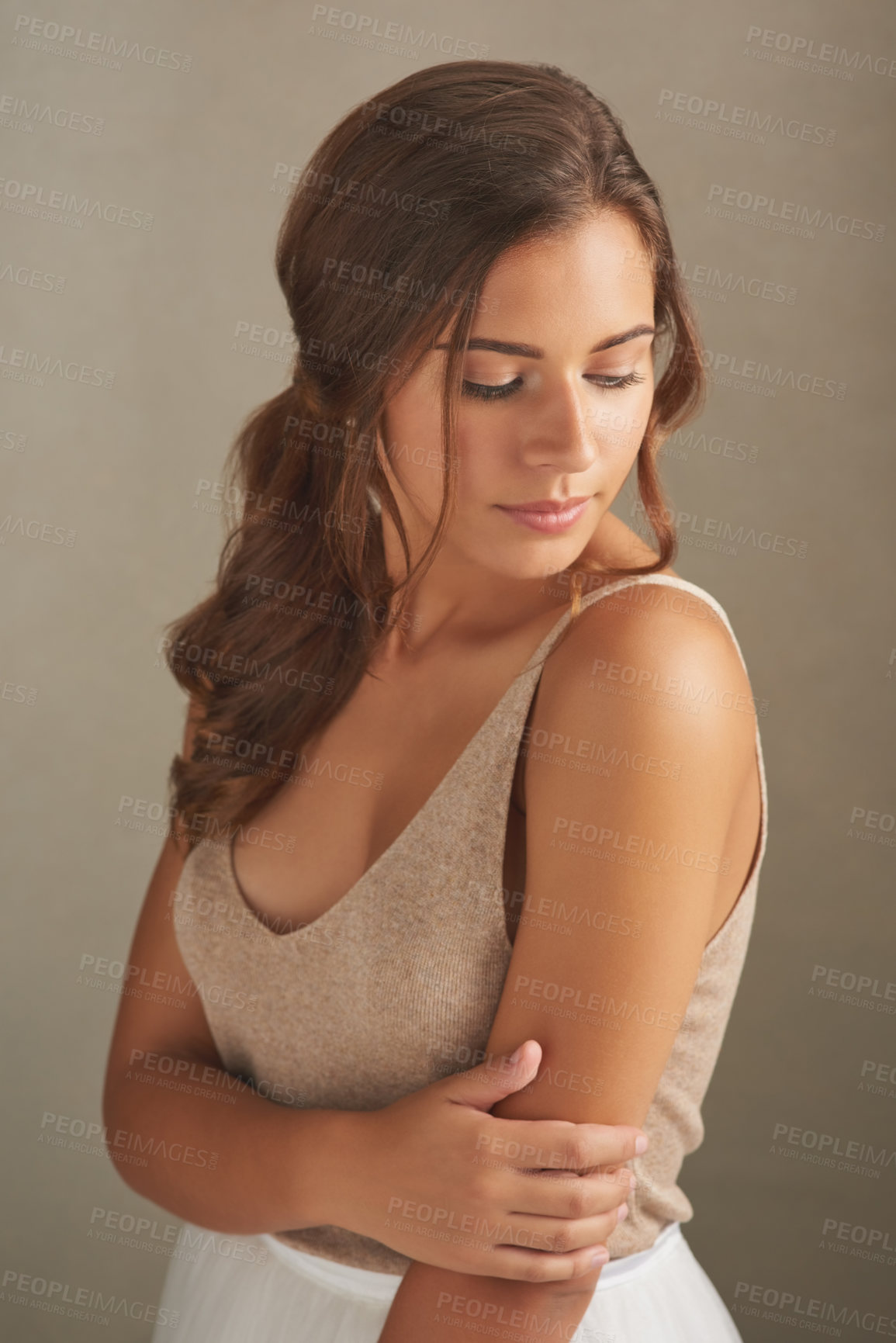 Buy stock photo Studio shot of an attractive young woman posing against a brown background