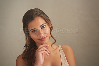 Buy stock photo Studio shot of an attractive young woman posing against a brown background