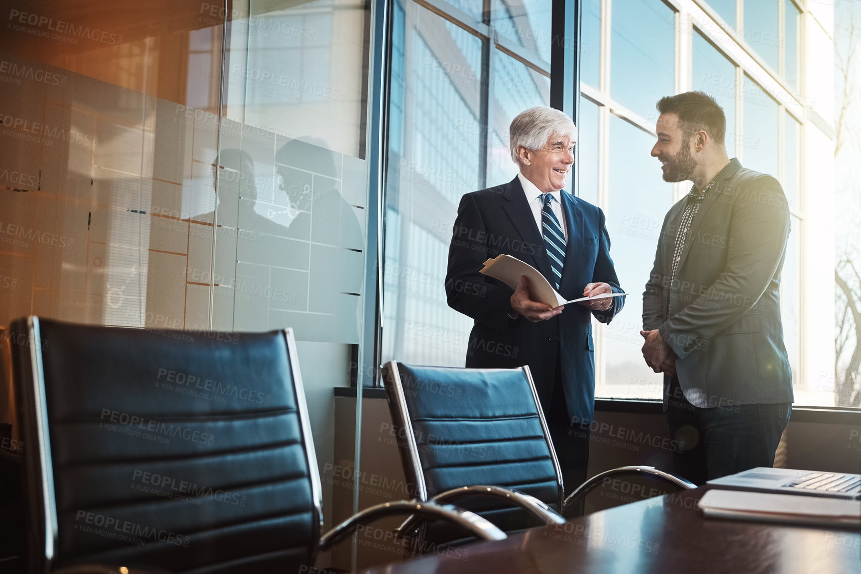 Buy stock photo Cropped shot of two businessmen looking over some paperwork in the office