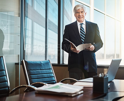 Buy stock photo Cropped portrait of a mature businessman reading paperwork in his office