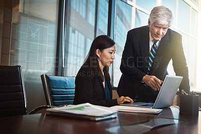 Buy stock photo Cropped shot of a businessman helping a female colleague with something on her laptop