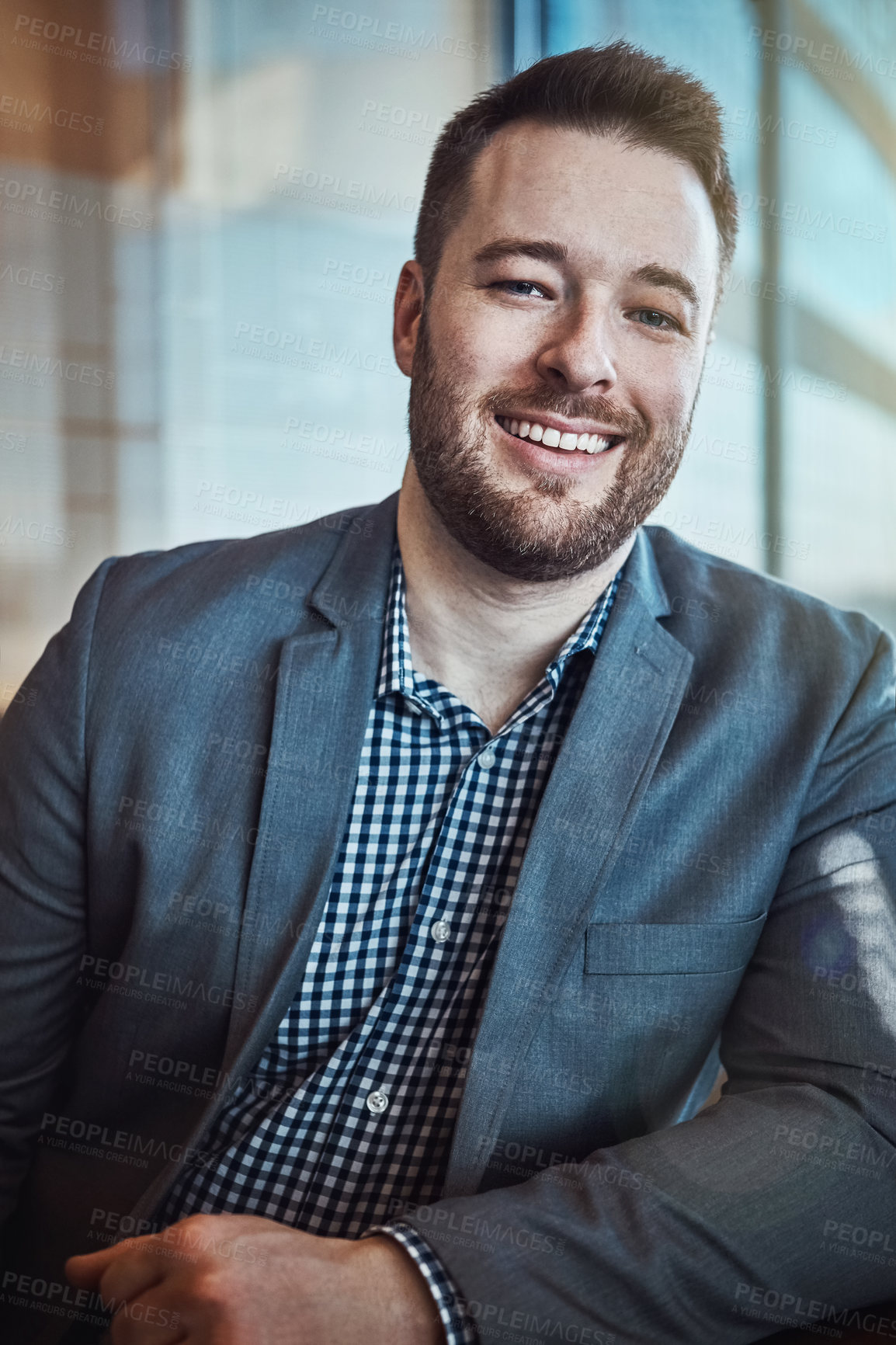 Buy stock photo Cropped portrait of a young businessman sitting in his office