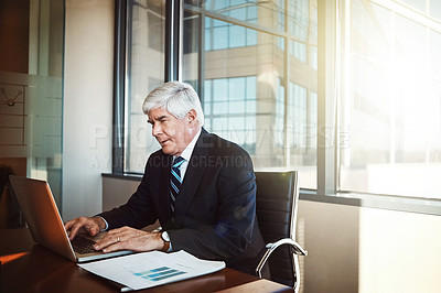 Buy stock photo Cropped shot of a mature businessman working on his laptop in the office