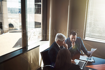 Buy stock photo High angle shot of three businesspeople working in the boardroom