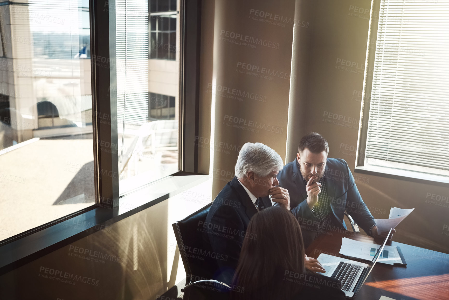 Buy stock photo High angle shot of three businesspeople working in the boardroom