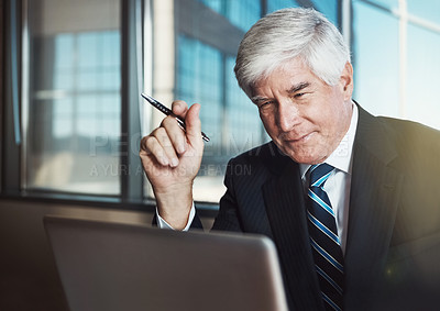 Buy stock photo Cropped shot of a mature businessman working on his laptop in the office