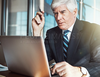 Buy stock photo Cropped shot of a mature businessman working on his laptop in the office