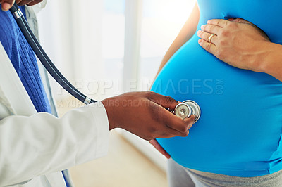 Buy stock photo Cropped shot of a doctor doing a checkup on a pregnant woman with a stethoscope